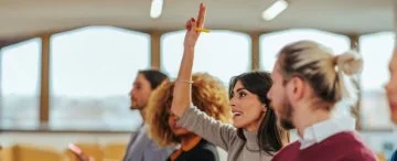 a training class with a student raising there hand.