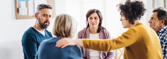 A group of people sitting a support group.