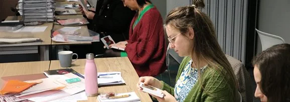 A women sitting in a training session reviewing learning materials. 