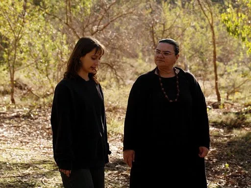 two Aboriginal Mental Health workers, walking through Kinds Park and talking.