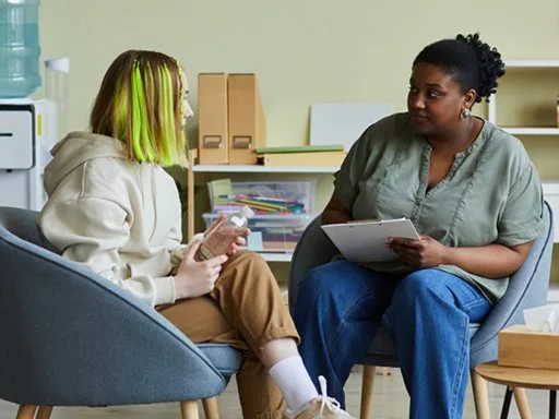 A teenage girl getting support from a mental health worker. 