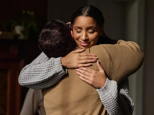 Two people hugging o show support for one another. 