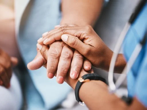 health professional holding hand of patient in support.
