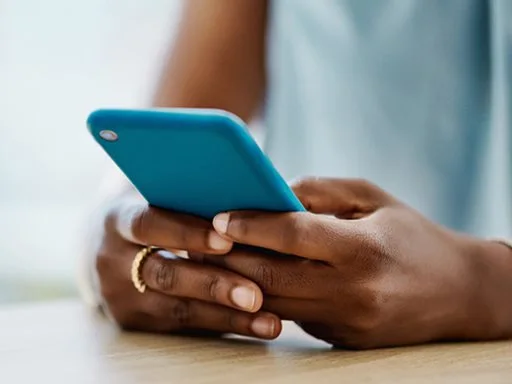 A person typing a message their phone on a live chat.