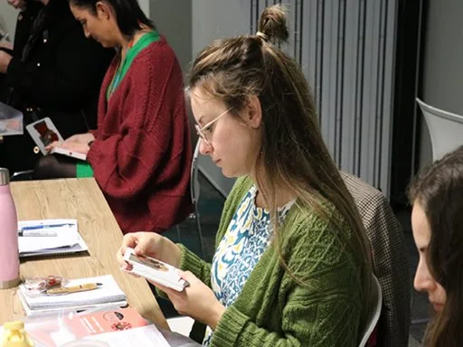 A women sitting in a training session reviewing learning materials. 