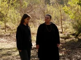 Two Aboriginal mental health workers walking together in the bush talking