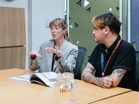 Two staff discussing the purpose and priorities of the Office of Alcohol and Other Drugs.