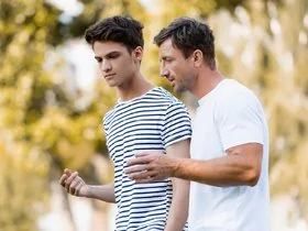 Two men walking outside in discussion.