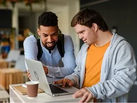 Support worker helping a young man with down syndrome.
