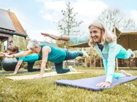 Older women outside doing yoga to help look after their wellbeing.