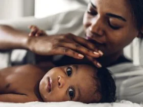 A women lying in bed with you new born baby.