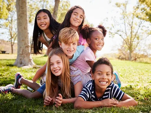 A group of six young children playing outside happily.