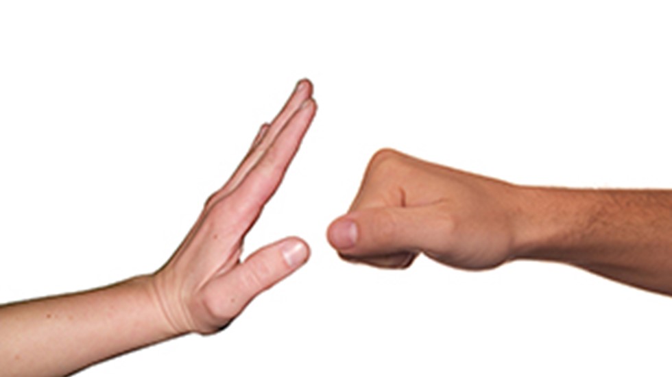 Two hands - person on left is indicating 'stop' and person on right has a clenched fist